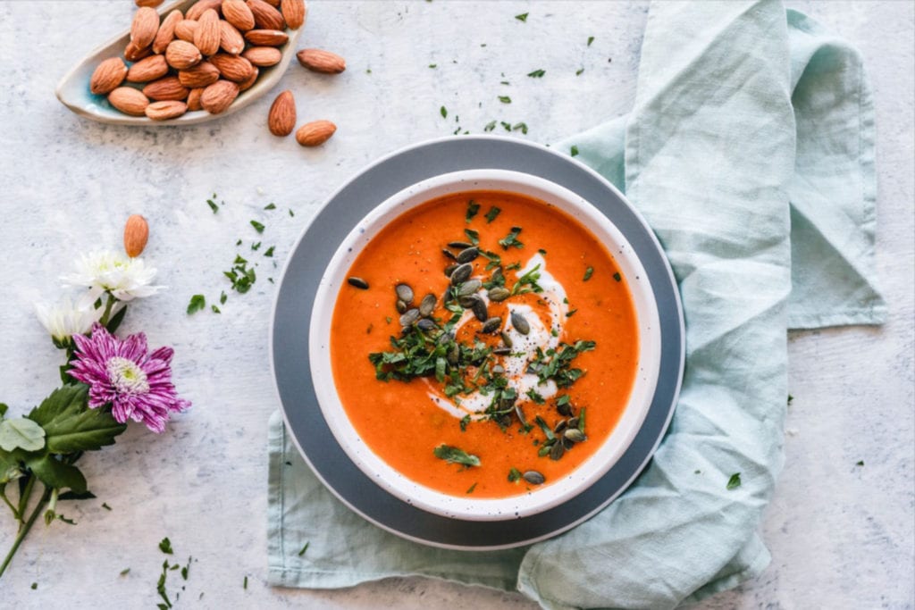 tomato soup on a table with almond nuts